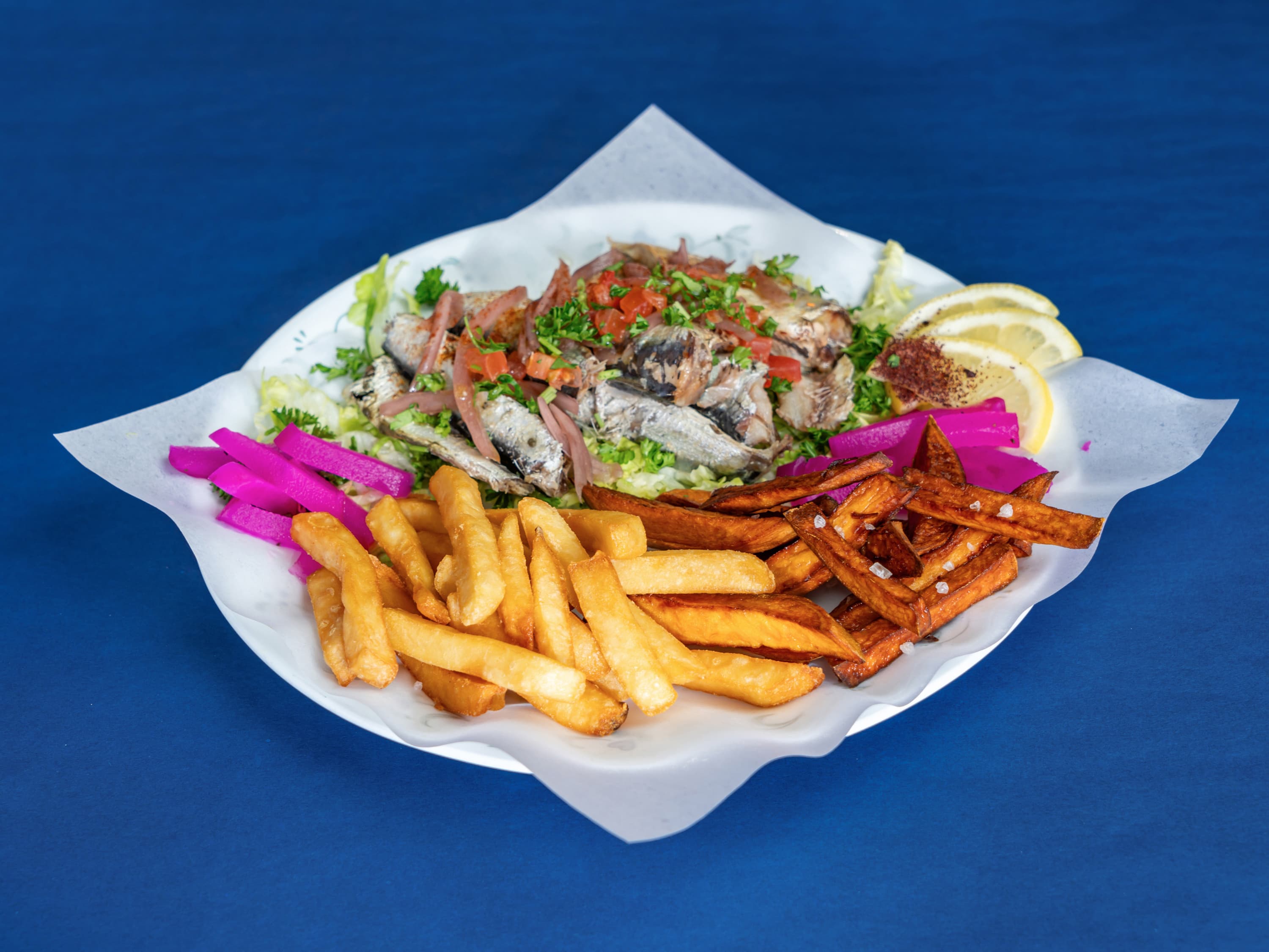 Grilled sardines with herbs and tomatoes, served with fries, sweet potato fries, and pickled turnips.